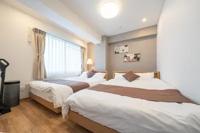 a bedroom with two beds and a window at Nestry Asakusa 403\u53f7\u5ba4 in Tokyo