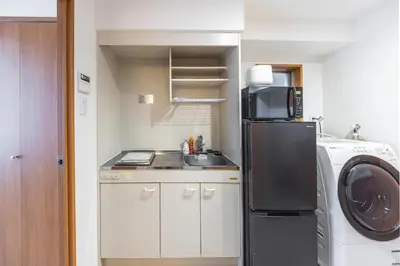 a small kitchen with a sink and a refrigerator at 20 minutes by Haneda Airport train 3-minute walk from Kamata Station Direct access to Tokyo, Yokohama, Ueno in Tokyo