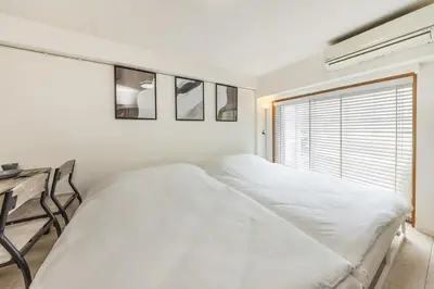 a white bedroom with two beds and a window at 20 minutes by Haneda Airport train 3-minute walk from Kamata Station Direct access to Tokyo, Yokohama, Ueno in Tokyo