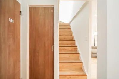 a hallway with a wooden door and stairs at Year-end promotion Shinjuku 401 Great Location 2 mins to S Station New Building Max for 6 people in Tokyo