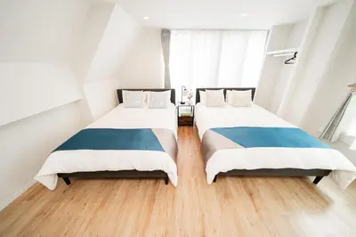 two beds in a room with white and blue at Year-end promotion Shinjuku 401 Great Location 2 mins to S Station New Building Max for 6 people in Tokyo