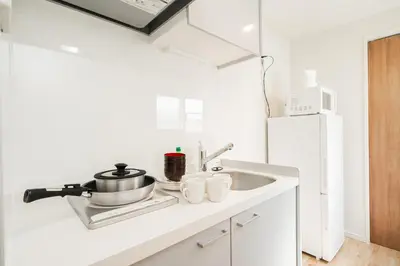 a white kitchen with a sink and a white refrigerator at Year-end promotion Shinjuku 401 Great Location 2 mins to S Station New Building Max for 6 people in Tokyo