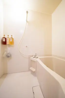 a white bathroom with a tub and a sink at THE MULTIPLE Shinjuku WEST in Tokyo