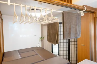 a drying rack in a kitchen with towels hanging from it at THE MULTIPLE Shinjuku WEST in Tokyo