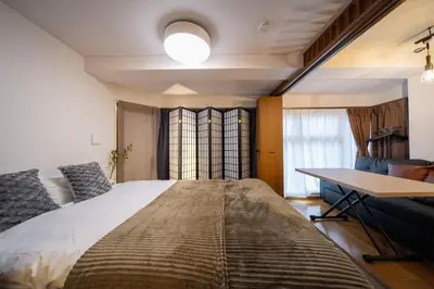a bedroom with a large bed and a desk at THE MULTIPLE Shinjuku WEST in Tokyo