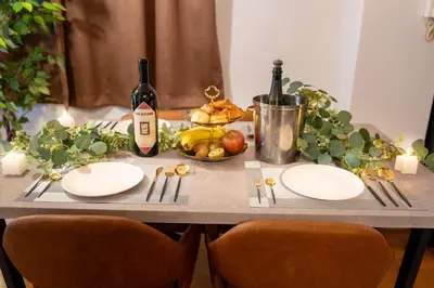 a table with two white plates and a bottle of wine at THE MULTIPLE Shinjuku WEST in Tokyo