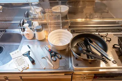 a kitchen counter with a sink with utensils at THE MULTIPLE Shinjuku WEST in Tokyo