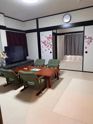 a dining room with a table and chairs and a clock at \u963f\u4e45\u6d25\u30cf\u30a4\u30c4201 in Tokyo