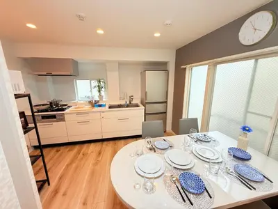 a kitchen with a table with plates and glasses on it at \u963f\u4e45\u6d25\u30cf\u30a4\u30c4201 in Tokyo