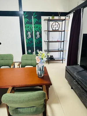 a living room with a wooden table and green chairs at \u963f\u4e45\u6d25\u30cf\u30a4\u30c4201 in Tokyo
