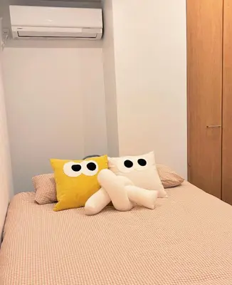 two stuffed hello kitty pillows sitting on a bed at TOMI Hotel in Tokyo