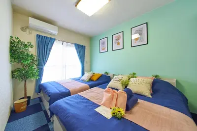 two beds in a room with blue walls at Shamrock Aoto 303 Cozy Tokyo Stay Near Station Airport Disney Access in Tokyo
