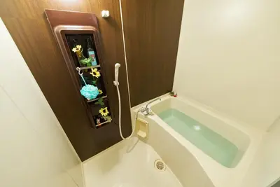 a bath tub in a small bathroom with flowers at Shamrock Aoto 303 Cozy Tokyo Stay Near Station Airport Disney Access in Tokyo