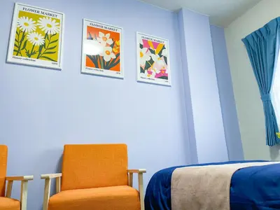 a room with a bed and a chair and posters at Shamrock Aoto 303 Cozy Tokyo Stay Near Station Airport Disney Access in Tokyo