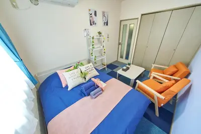 a bedroom with a blue bed and two chairs at Shamrock Aoto 303 Cozy Tokyo Stay Near Station Airport Disney Access in Tokyo