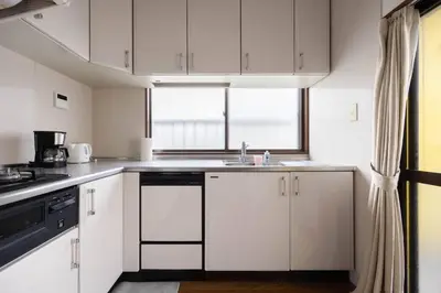 a kitchen with white cabinets and a sink and a window at \u5713\u798f\u30d3\u30eb in Tokyo
