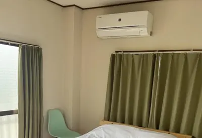 a bedroom with a air conditioner on the wall at \u5713\u798f\u30d3\u30eb in Tokyo