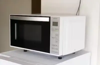 a microwave oven sitting on top of a white counter at \u5713\u798f\u30d3\u30eb in Tokyo