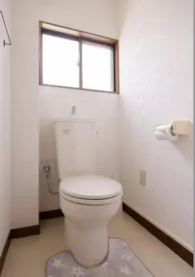 a white toilet in a bathroom with a window at \u5713\u798f\u30d3\u30eb in Tokyo