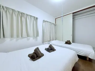 two beds with towels on top of them in a room at Terrace Stay Omori in Tokyo