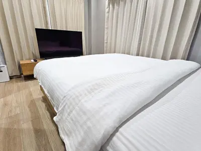 a bedroom with a white bed and a flat screen tv at Hotel Yado SK Shinkoiwa - Vacation STAY 17432v in Tokyo