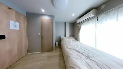 a bed in a room with a door and a window at Hotel Yado SK Shinkoiwa - Vacation STAY 17543v in Tokyo