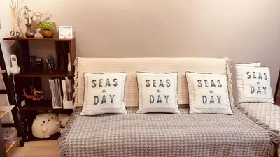 a bed with four pillows saying seas of day at \u6c60\u888b\u7ad9\u6b65\u884c3\u5206\u949f \u56e2\u4f536-10\u4eba\u5165\u4f4f in Tokyo