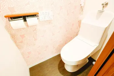 a bathroom with a white toilet and pink wallpaper at Shinjuku 4bed rooms apartment#4室2厅2浴室2卫生间#智能马桶#高速无限制网路3&1 in Tokyo