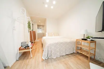 a bedroom with a bed and a wooden floor at Waseda Star New Open Station 2 Minutes in Tokyo