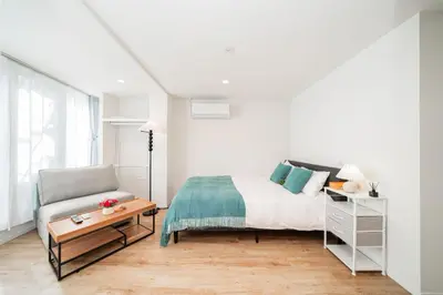 a bedroom with a bed and a chair and a table at Waseda Star New Open Station 2 Minutes in Tokyo