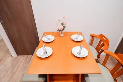 a wooden table with two plates and flowers on it at Waseda Star New Open Station 2 Minutes in Tokyo