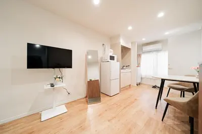 a living room with a table and a tv on the wall at Waseda Star New Open Station 2 Minutes in Tokyo