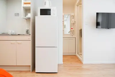 a white refrigerator in a kitchen with a microwave at Waseda Star New Open Station 2 Minutes in Tokyo