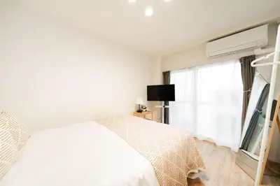 a white bedroom with a bed and a window at Waseda Star New Open Station 2 Minutes in Tokyo