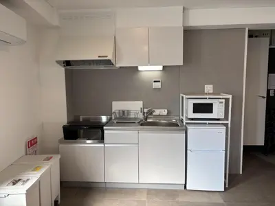 a kitchen with white cabinets and a sink and a microwave at \u3042\u3059\u304b\u30ec\u30b8\u30c7\u30f3\u30b9 \u304b\u3064\u3057\u304b in Tokyo