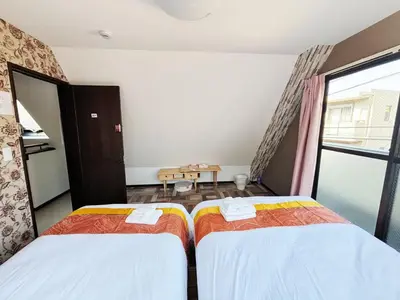 two twin beds in a room with a window at \u82b1\u306e\u91cc in Tokyo