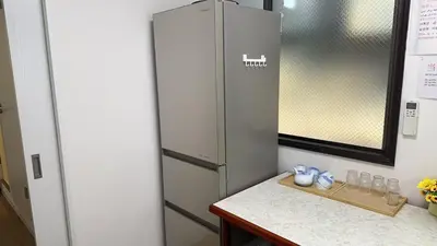 a kitchen with a refrigerator and a counter with glasses at \u82b1\u306e\u91cc in Tokyo