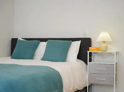 a bed with blue and white pillows and a night stand at OpenSale Shinjuku 301 New Building 2mins to Waseda Station Max for 3 people in Tokyo