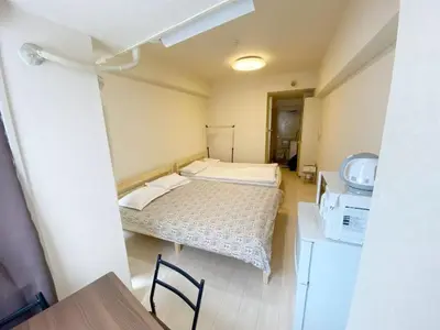 a small room with a bed and a microwave at Ikebukuro Center#sunny#\u6c60\u888b\u4e2d\u5fc3\u5730\u5e26#\u9633\u5149\u516c\u5bd3#\u8f66\u7ad9\u6b65\u884c5\u5206#\u9ad8\u901f\u65e0\u9650\u5236\u7f51\u8def#\u65b0\u88c5\u4fee\u9ad8\u7ea7\u516c\u5bd3#\u5165\u53e3\u81ea\u52a8\u9632\u76d7\u4e0a\u9501\u95e8#\u4e1c\u5efa702 in Tokyo