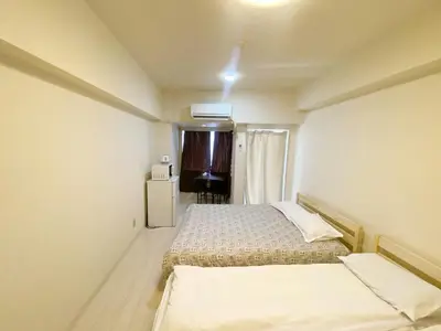 a small room with two beds and a refrigerator at Ikebukuro Center#sunny#\u6c60\u888b\u4e2d\u5fc3\u5730\u5e26#\u9633\u5149\u516c\u5bd3#\u8f66\u7ad9\u6b65\u884c5\u5206#\u9ad8\u901f\u65e0\u9650\u5236\u7f51\u8def#\u65b0\u88c5\u4fee\u9ad8\u7ea7\u516c\u5bd3#\u5165\u53e3\u81ea\u52a8\u9632\u76d7\u4e0a\u9501\u95e8#\u4e1c\u5efa702 in Tokyo