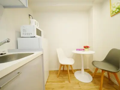 a kitchen with a sink and a table with two chairs at OpenSale Shinjuku 302 New Build 2mins to Waseda Station Max for 2 people in Tokyo