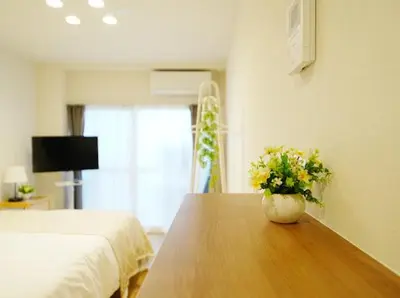 a bedroom with a table with a vase of flowers on it at OpenSale Shinjuku 302 New Build 2mins to Waseda Station Max for 2 people in Tokyo