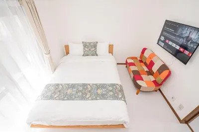 a small bedroom with a bed and a chair at Shinjuku Terrace 226 BnB in Tokyo
