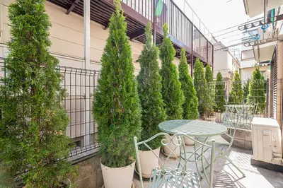 a patio with a table and potted trees at Shinjuku Terrace 226 BnB in Tokyo