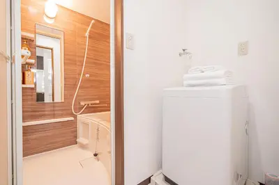 a small bathroom with a refrigerator and a shower at Shinjuku Terrace 226 BnB in Tokyo