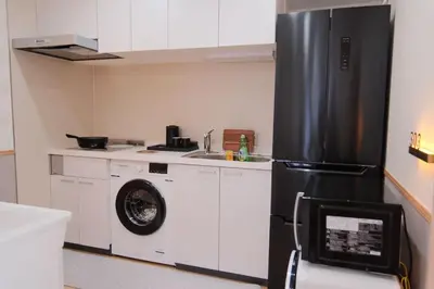 a kitchen with a refrigerator and a washing machine at \u6771\u4eac\u685c\u306e\u5bbf in Tokyo