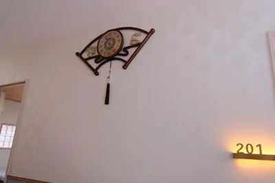 a clock hanging on a wall in a room at \u6771\u4eac\u685c\u306e\u5bbf in Tokyo