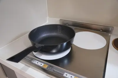 a black pot sitting on top of a stove at \u6771\u4eac\u685c\u306e\u5bbf in Tokyo