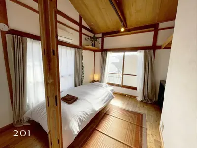 a bedroom with a bed in a room with windows at YutoVillageHouse Sweetexperience in Ikebukuro YVM in Tokyo