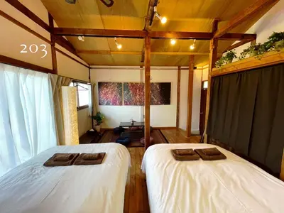 two beds in a room with wooden floors at YutoVillageHouse Sweetexperience in Ikebukuro YVM in Tokyo